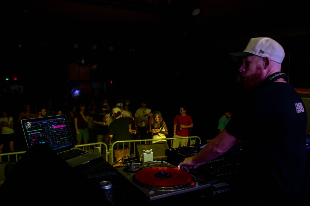 Andy Bruh silhouetted against LED graphics, red wash
