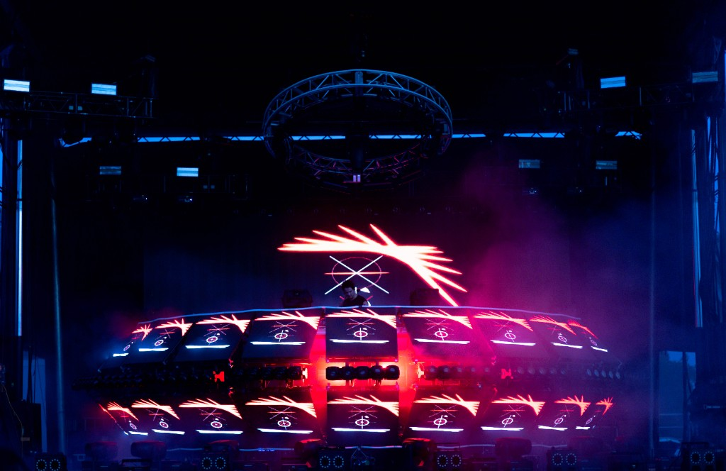 Saucer LED booth at night — crosshair panels, red wash