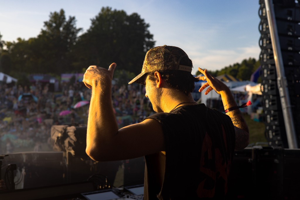 Daggz arms raised toward the hill — golden hour