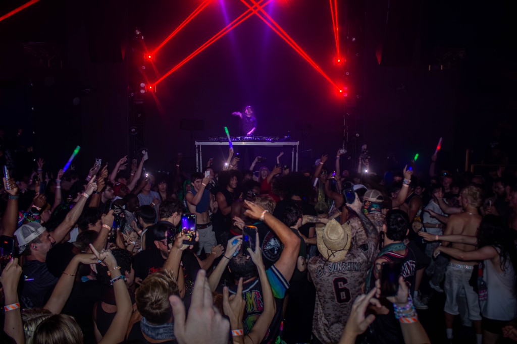 Crowd under red lasers, Eptic silhouetted at the booth