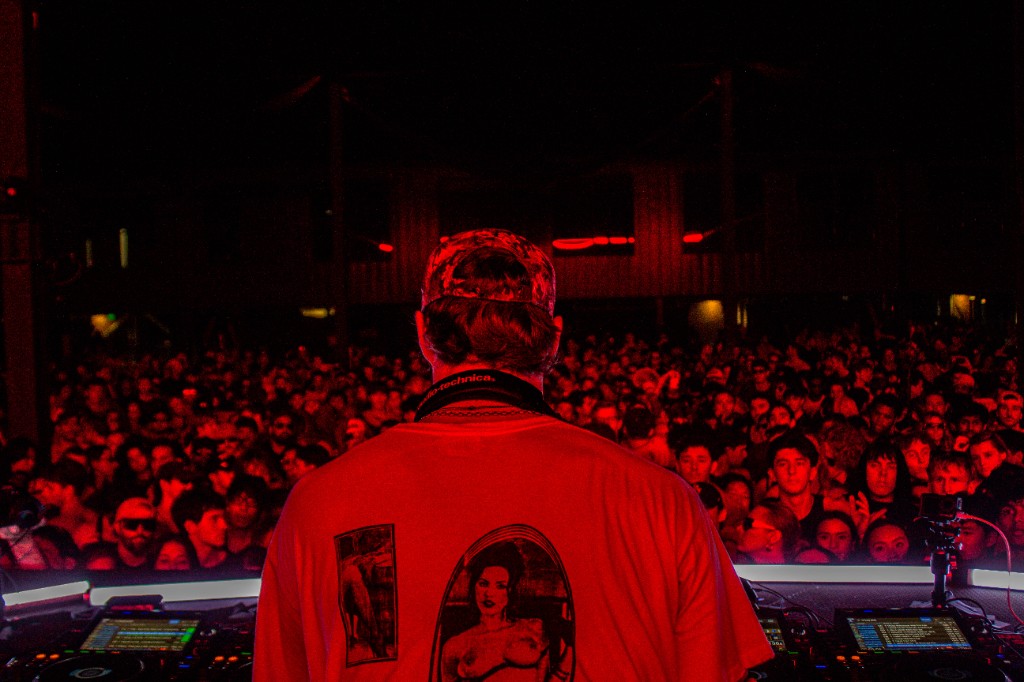 From behind It's Murph — graphic tee, headphones, red wash